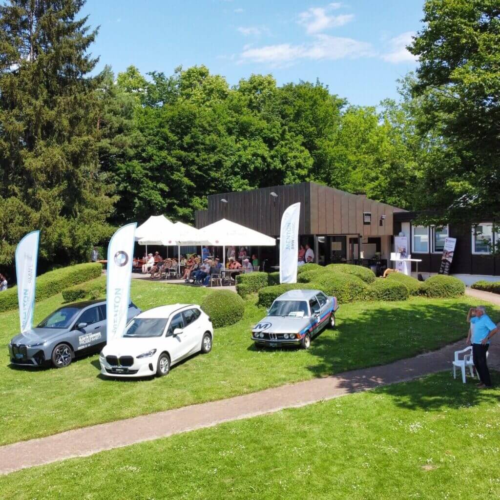 BMW Autos vor Café bei sonnigem Tag