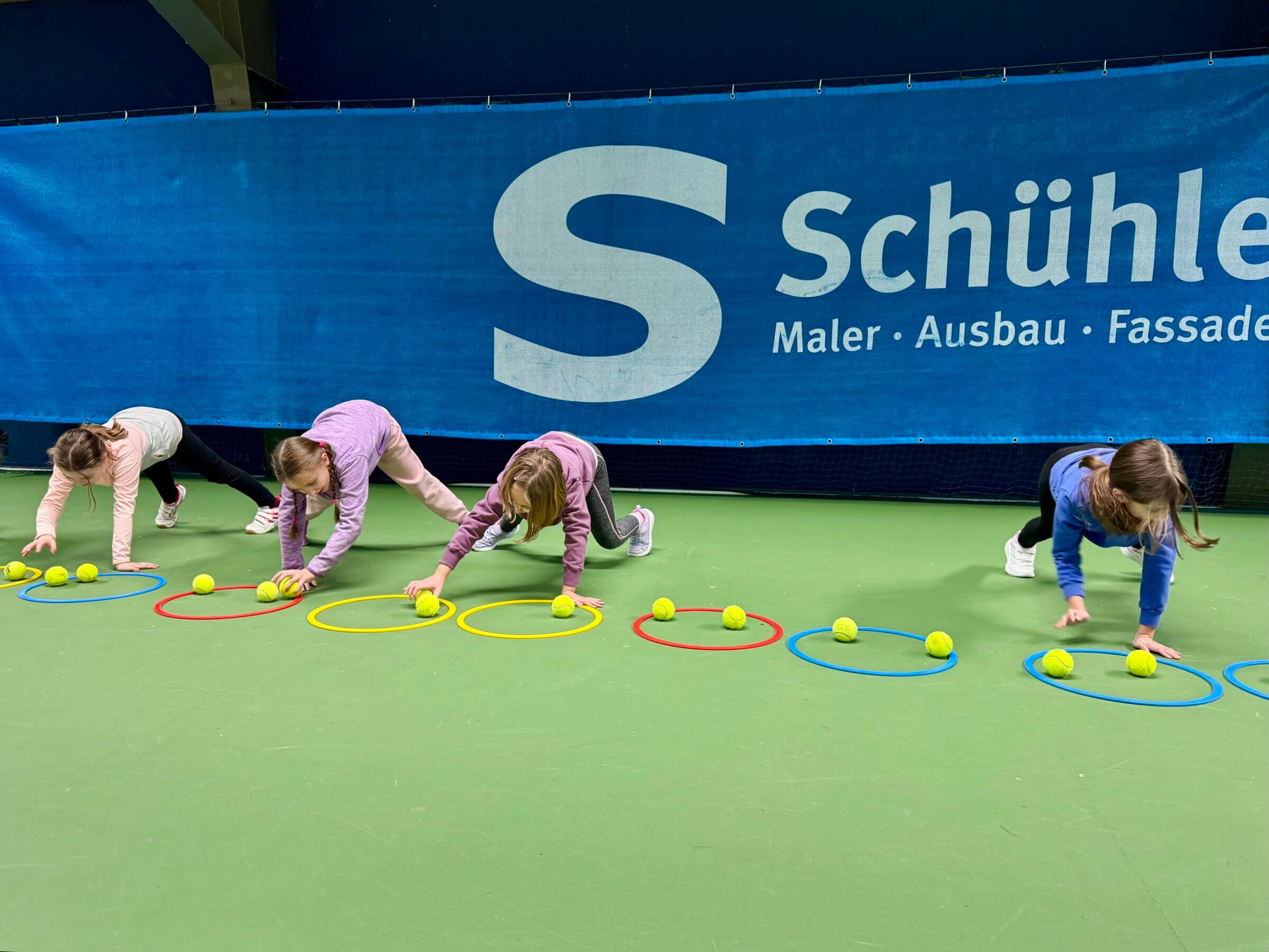 Kinder spielen mit Tennisbällen in der Sporthalle
