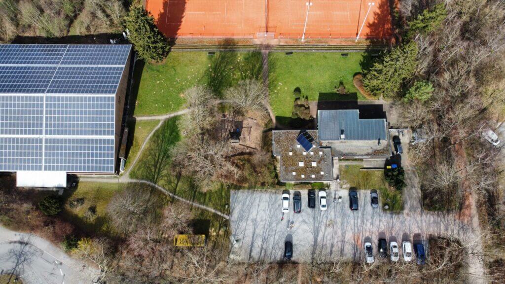 Luftaufnahme von Tennisanlage mit Solardach und Parkplatz