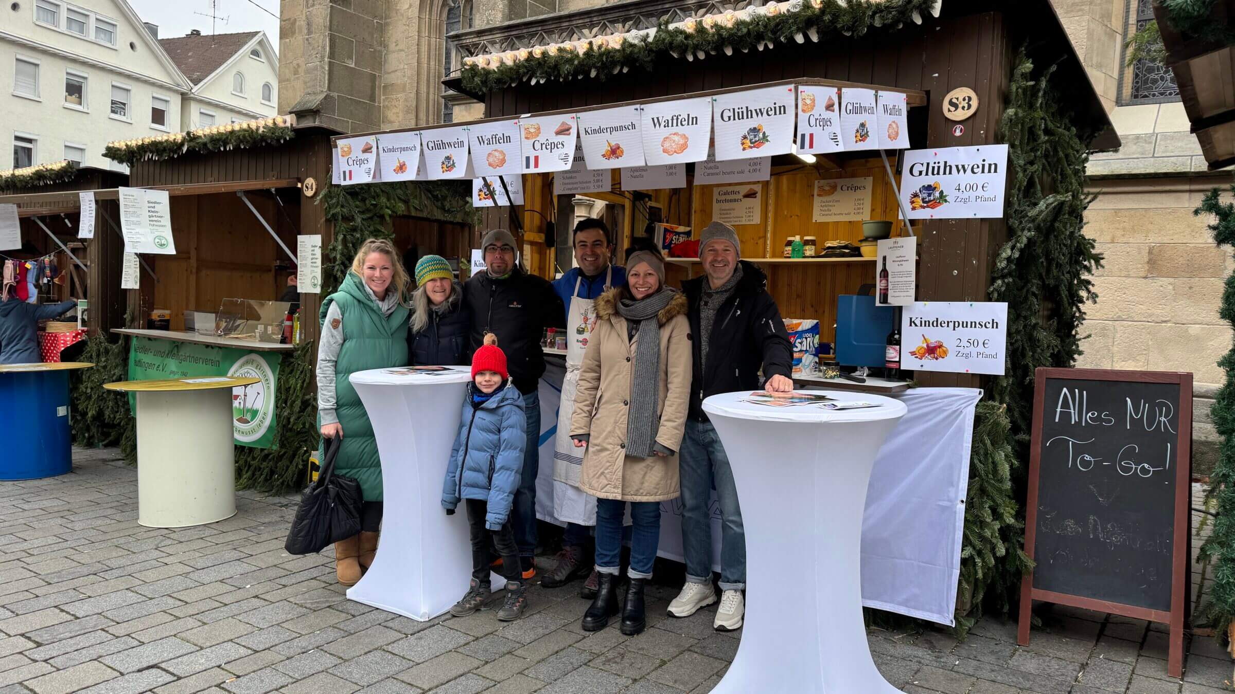 Menschen am Glühweinstand auf dem Weihnachtsmarkt