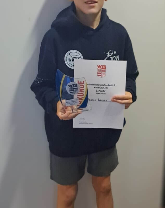 Junge hält Urkunde und Pokal für Sportwettbewerb