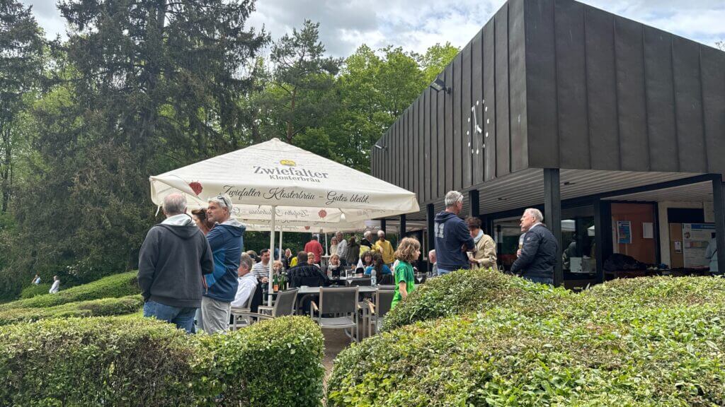 Menschen genießen Getränke im Freien unter Sonnenschirmen