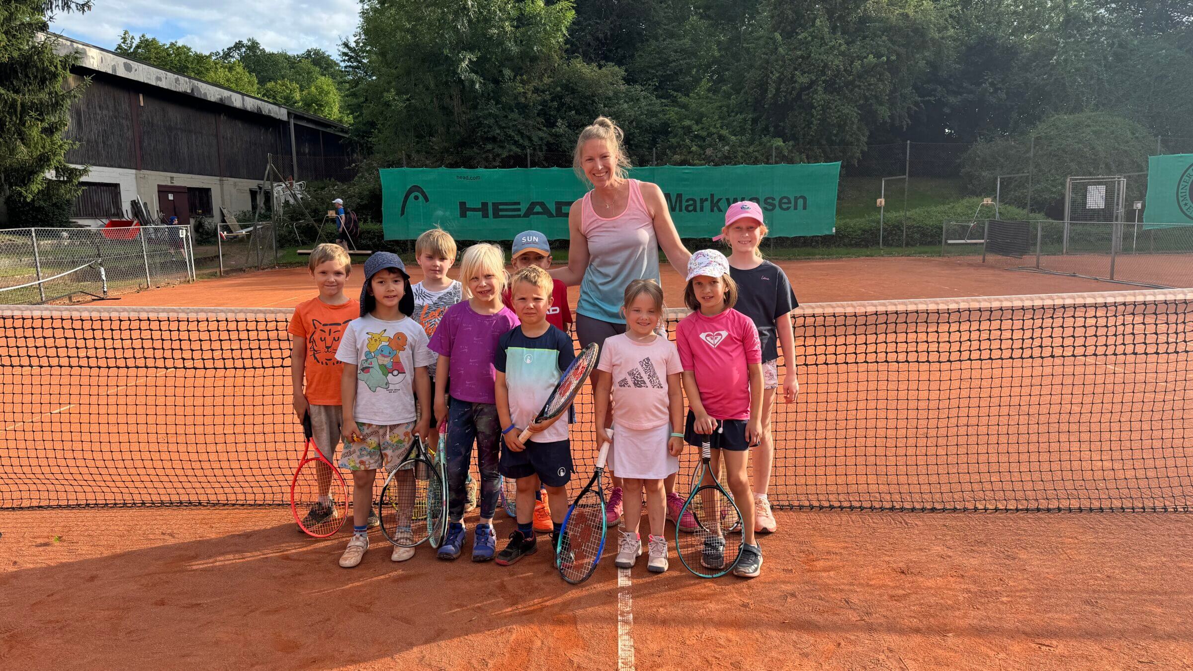 Kinder beim Tennistraining auf dem Sandplatz