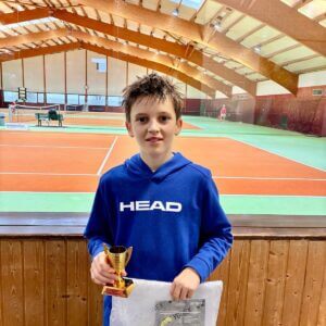 Junge hält Tennis-Pokal in Halle