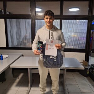 Junger Mann hält Urkunde und Pokal bei Preisverleihung